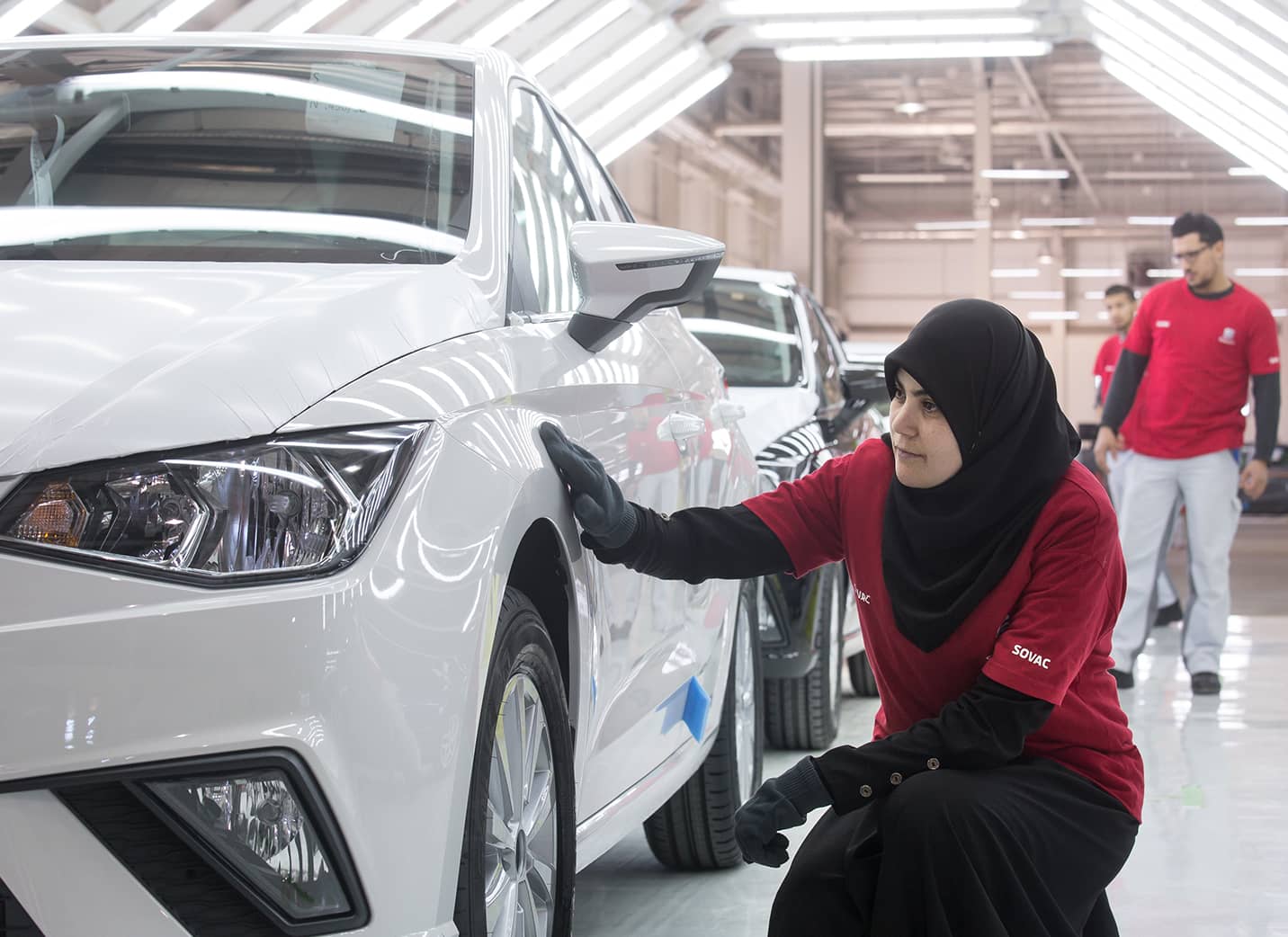 SEATi tehase naistöötaja kontrollimas uut autot vasaku esiratta juurest – SEAT tööandjana