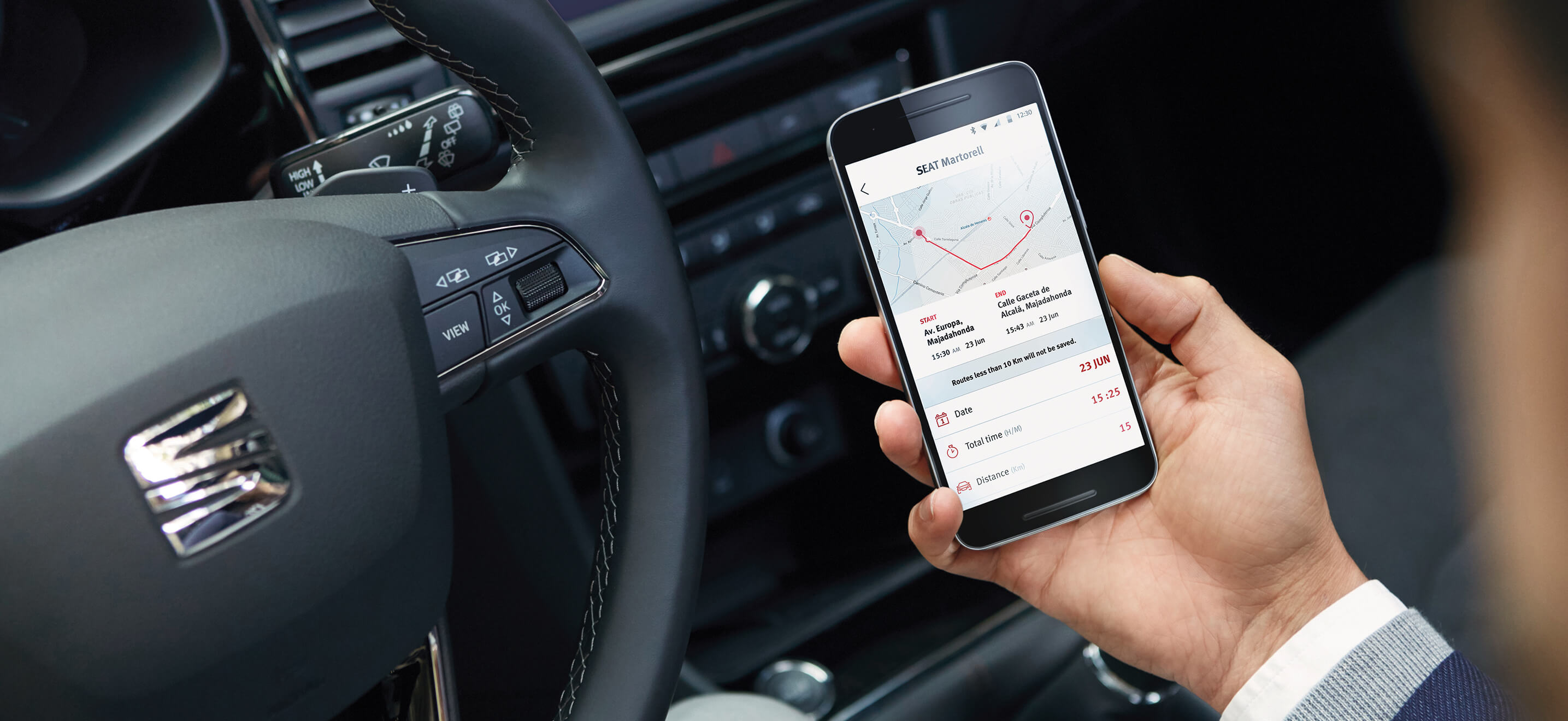 SEAT new car services and maintenance – My SEAT App in action in a car driver holding a phone