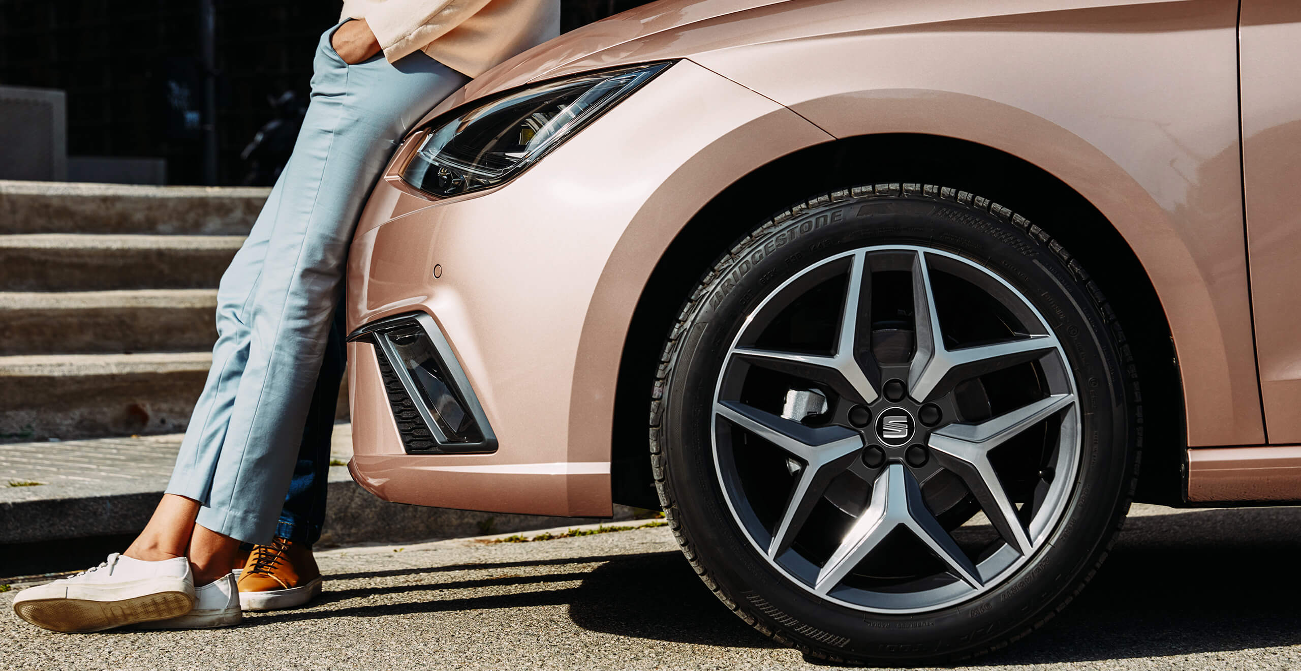 SEAT uue auto teenindus, hooldus, tehnoülevaatuse eelne kontroll – naine nõjatub roosa kuldse SEATi vastu